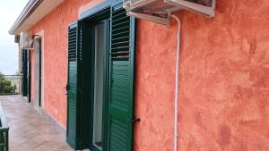a green shutter on the side of a building at Domus amica 1 in Finocchito
