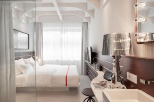 ein Schlafzimmer mit einem Bett, einem Waschbecken und einem Spiegel in der Unterkunft Ruby Lotti Hotel Hamburg by IHG in Hamburg + 78 Fotos