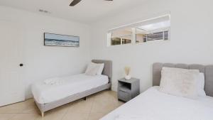 a bedroom with two beds and a window at Florida Paradyse 10MIN DOWNTOWN Y 10 MIN BEACH in Fort Myers +27 photos