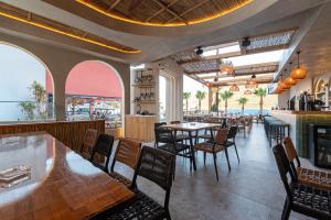 a dining room with tables and chairs in a restaurant at Bali Seaside Sailor in Bali