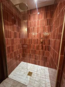 a bathroom with a shower with brown tile at Margate Manor - Rooms by the Sea in Margate