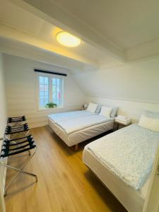 a bedroom with two beds and a window at Vinkelgata 20 Guesthouse in Stavanger