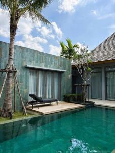 a swimming pool with a bench next to a building at Lucky Eight Villa in Ban Phru Champa