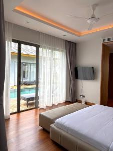 a bedroom with a bed and a television and a pool at Lucky Eight Villa in Ban Phru Champa +34 photos
