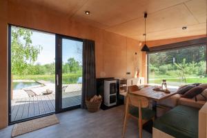 a living room with a large glass door and a table at РІЗНОтрав'я in Solygy +37 photos