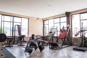 a gym with weights and other equipment in a room with windows at Hotel Samka in Salta