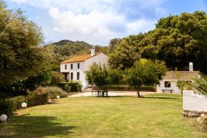 a white house with a yard and trees at Finca Santa Teresa, Casa La Higuera in Casares