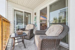 two wicker chairs and a table on a porch at Cherry Grove Condo Steps to Beach Sleeps 8 in Myrtle Beach