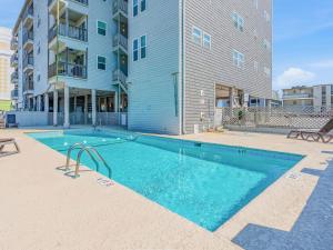 a swimming pool in front of a apartment building at Cherry Grove Condo Steps to Beach Sleeps 8 in Myrtle Beach