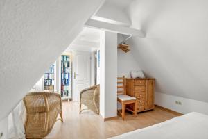 a bedroom with a bed and a desk and chairs at Achtern Diek in Schülp