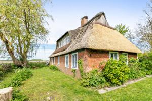 an old brick house with a thatched roof at Achtern Diek in Schülp
