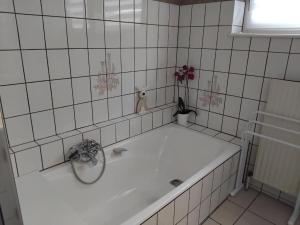 a bath tub in a tiled bathroom at "Parenthèse Alsacienne" in Luttenbach-près-Munster +38 photos
