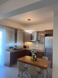 eine Küche mit einem Holztisch und einem Kühlschrank in der Unterkunft Rea Harmony in Kalamata