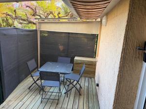 a patio with a table and chairs on a deck at Appartement 4 personnes in Sainte-Maxime