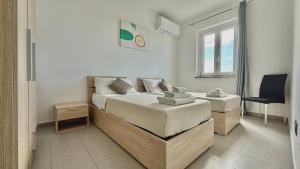 a bedroom with two beds and a chair in it at Sunrise Residence in Santa Domenica +46 photos