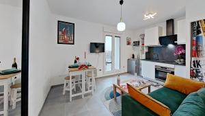 a living room with a couch and a kitchen at Appartement Elégant & Raffiné in Noisy-le-Grand