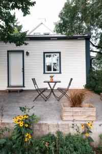 a patio with two chairs and a table in front of a house at Triangle de l'Île Chambre Belle Bleue in Saint-Laurent-de-l'ile d'Orleans +3 photos
