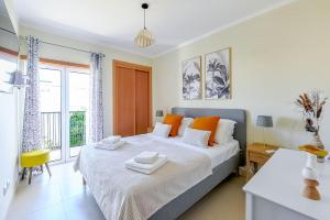 a bedroom with a large bed with orange pillows at Olive Tree penthouse in Tavira +58 photos