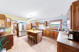 a kitchen with wooden cabinets and a stainless steel refrigerator at Point Au Roche Lodge in Plattsburgh