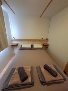 a bedroom with two beds with towels on it at Mobile home Magdalena in Pirovac