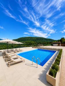 a pool with chairs and umbrellas on a patio at Lake View Apartament 10 - Free Parking & Terrace in Cadegliano Viconago
