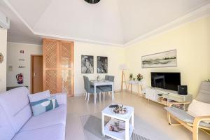 a living room with a purple couch and a tv at Olive Tree penthouse in Tavira