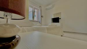 a room with a bed and a table with a lamp at Sunrise Residence in Santa Domenica