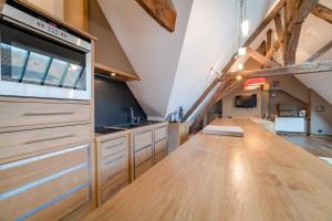 a large kitchen with a wooden counter top in an attic at Robillard 2 - Bail Partner in Auxerre