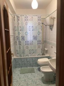 a bathroom with a toilet and a sink and a shower at Casa Paradiso in Palazzo Adriano +11 photos