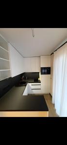 a kitchen with white cabinets and a black counter top at House on The Hill Bukovel in Palyanytsya