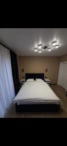a bedroom with a large bed with white sheets at House on The Hill Bukovel in Palyanytsya