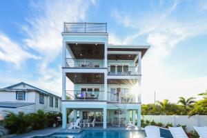 a white house with a swimming pool in front of it at Bayfront Retreat in Bradenton Beach