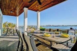 a dining table on a deck with a view of the water at Bayfront Retreat in Bradenton Beach