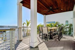 a patio with a table and chairs on a balcony at Bayfront Retreat in Bradenton Beach