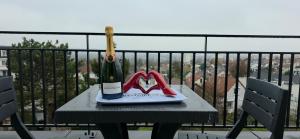a bottle of wine on a table on a balcony at Appartement Elégant & Raffiné in Noisy-le-Grand