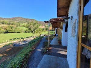 eine Tür zu einem Gebäude mit Blick auf ein Feld in der Unterkunft Chalé Tekoá - Aroeira, Baraúna e Juazeiro in Córrego do Bom Jesus + 11 Fotos