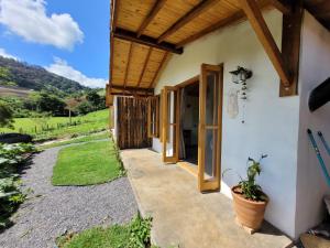 Ein Weg, der zum Eingang eines Hauses mit Holzdecke führt in der Unterkunft Chalé Tekoá - Aroeira, Baraúna e Juazeiro in Córrego do Bom Jesus