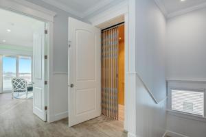 a hallway with white walls and a door with a window at Bayfront Retreat in Bradenton Beach
