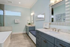 a bathroom with two sinks and a large mirror at Bayfront Retreat in Bradenton Beach +46 photos