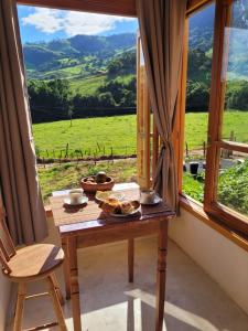 ein Tisch vor einem Fenster mit Aussicht in der Unterkunft Chalé Tekoá - Aroeira, Baraúna e Juazeiro in Córrego do Bom Jesus