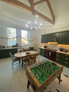 a large kitchen with a table with a pool table at Russell Hill Manor in Peterborough