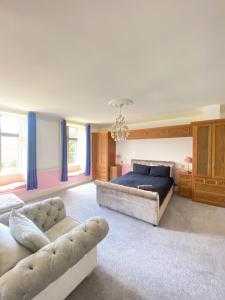 a bedroom with a bed and a couch at Russell Hill Manor in Peterborough