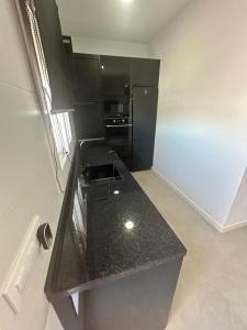 a kitchen with a black counter top in a room at Atico casa la via in Sanlúcar de Barrameda