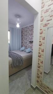 a bedroom with a bed and a brick wall at Dois quartos mobiliado próximo a praia in Vila Velha