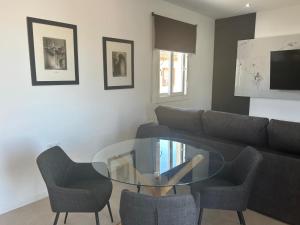 a living room with a glass table and chairs at Atico casa la via in Sanlúcar de Barrameda
