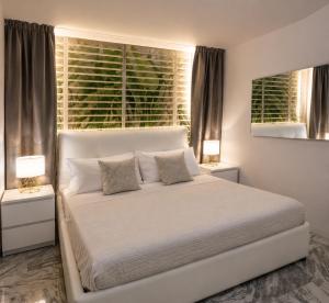 a white bed in a bedroom with two lamps at La Galleria Milano - 160 sqm Design Apartment, Spa & Parking in Milan