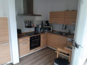 a small kitchen with wooden cabinets and a stove at Landhaus Sevenich in Münstermaifeld +6 photos