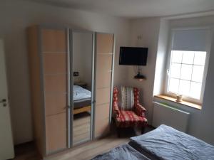 a bedroom with a closet and a bed and a chair at Landhaus Sevenich in Münstermaifeld
