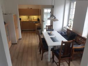 a kitchen and dining room with a white table and chairs at Landhaus Sevenich in Münstermaifeld