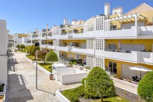 a large white building with bushes in front of it at Olive Tree penthouse in Tavira